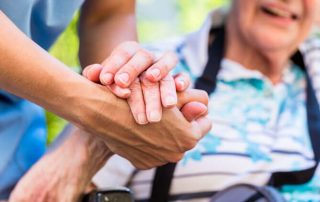 Caregiver holding elder person's hand - links to 2026 Alzheimer’s Disease Initiative Request for Proposal (RFP)